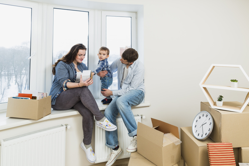 young-family-relaxing-their-new-home-with-moving-cardboard-boxes.jpg